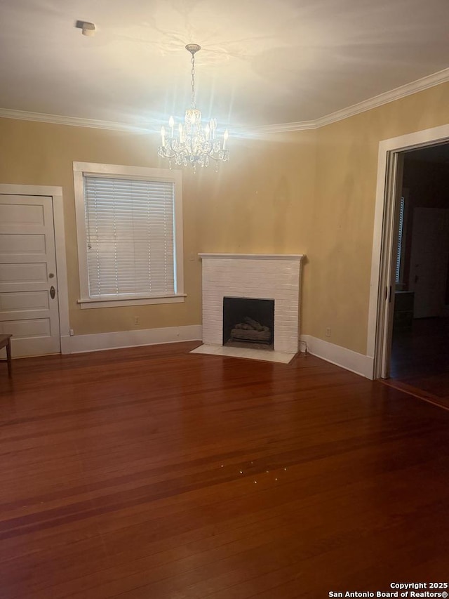 unfurnished living room with an inviting chandelier, hardwood / wood-style flooring, a high end fireplace, and ornamental molding