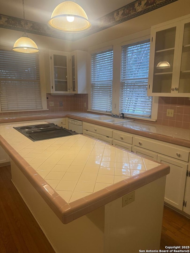 kitchen featuring hanging light fixtures, decorative backsplash, tile counters, and white cabinets