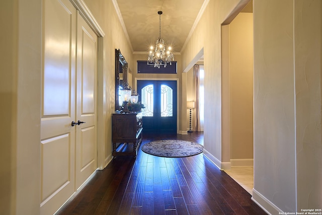 foyer featuring crown molding, dark hardwood / wood-style floors, french doors, and a chandelier