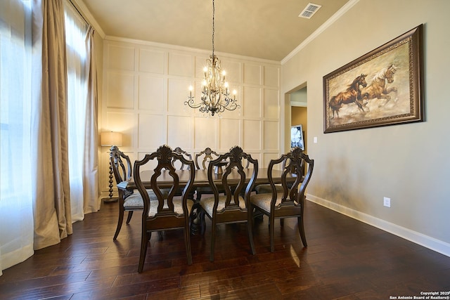 dining room with an inviting chandelier, ornamental molding, and dark hardwood / wood-style floors