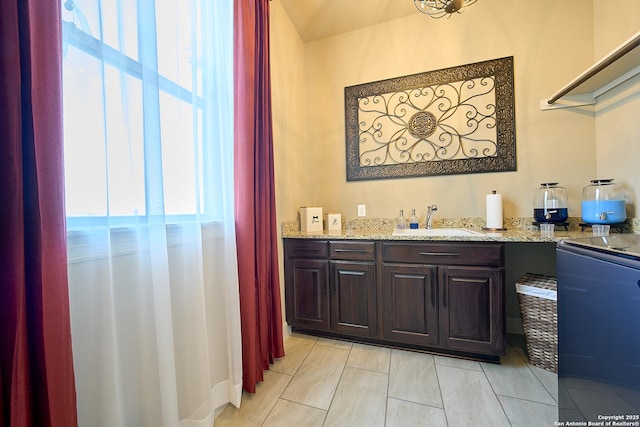 bar featuring sink, light tile patterned floors, and light stone counters