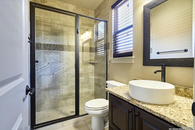 bathroom with vanity, tile patterned flooring, a shower with shower door, and toilet