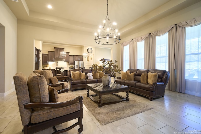 living room featuring a notable chandelier and a tray ceiling