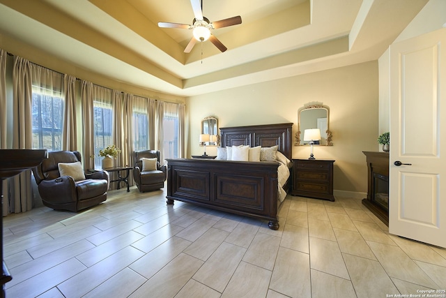 bedroom featuring a raised ceiling and ceiling fan