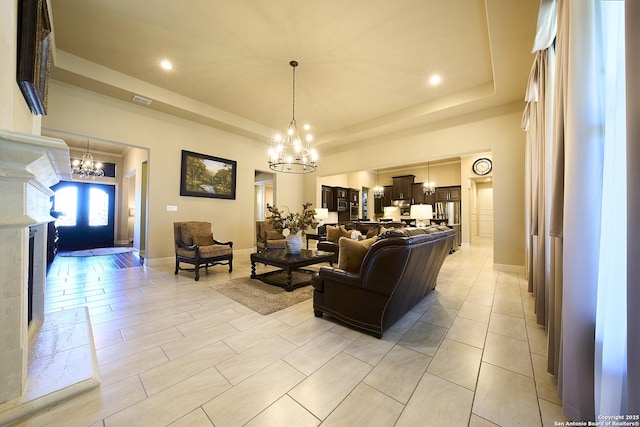 living room featuring a tray ceiling and a notable chandelier