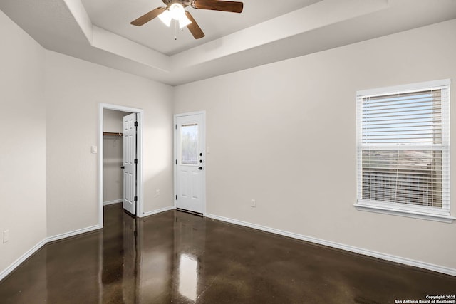 spare room with a raised ceiling and ceiling fan