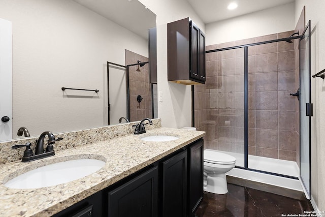 bathroom featuring vanity, a shower with door, and toilet