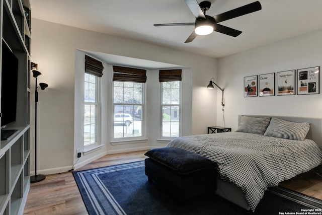 bedroom featuring light wood-type flooring, ceiling fan, and baseboards