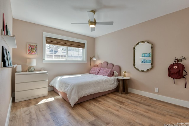 bedroom featuring a ceiling fan, baseboards, and wood finished floors