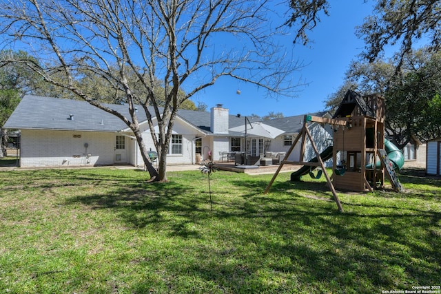 view of yard featuring a playground and a patio