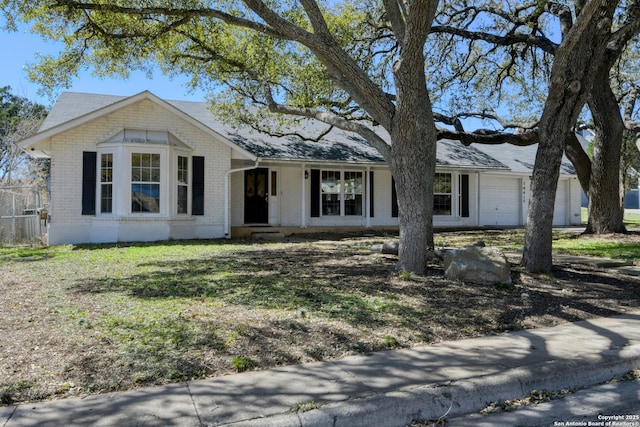 ranch-style home featuring an attached garage and brick siding