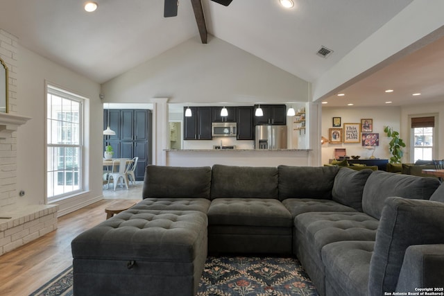 living area featuring recessed lighting, visible vents, light wood-style flooring, high vaulted ceiling, and beamed ceiling