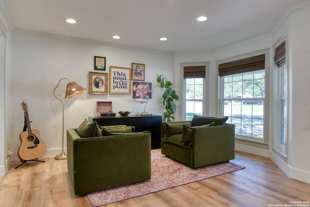 living area with baseboards, light wood-style floors, recessed lighting, and crown molding