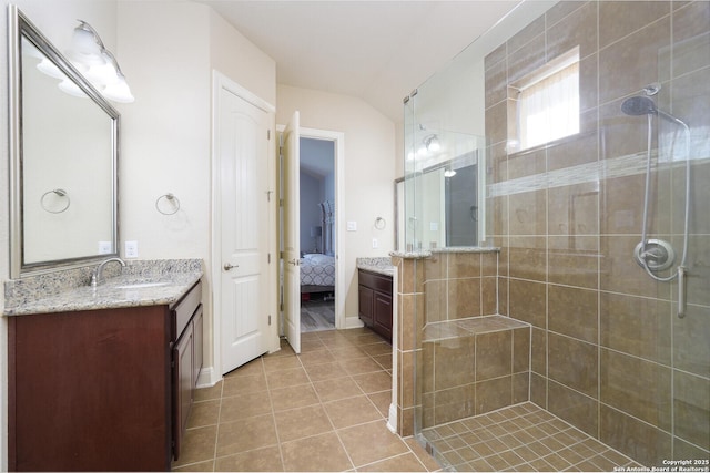 bathroom with tile patterned flooring, vanity, a shower with shower door, and lofted ceiling