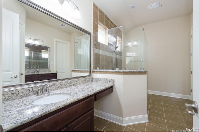 bathroom with vaulted ceiling, vanity, a shower with shower door, and tile patterned flooring