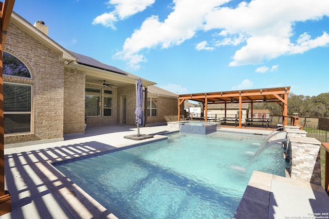 view of pool featuring a patio, pool water feature, and an in ground hot tub