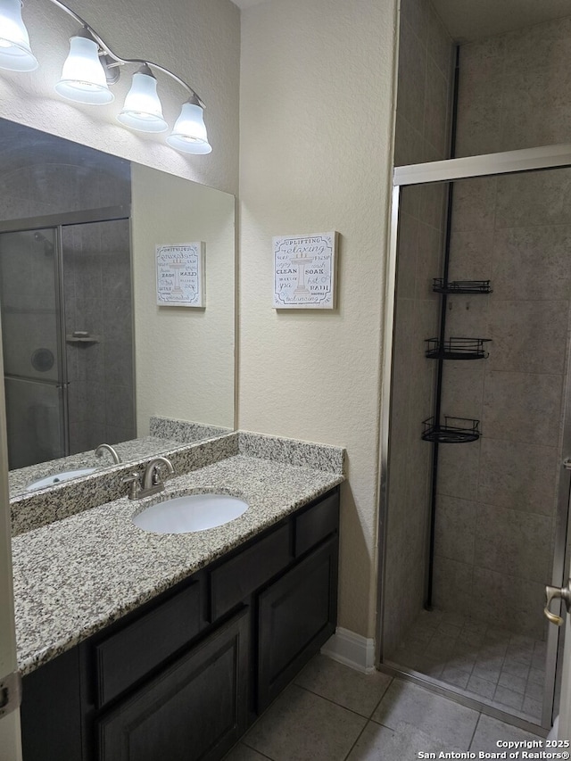 bathroom featuring vanity, tile patterned floors, and walk in shower