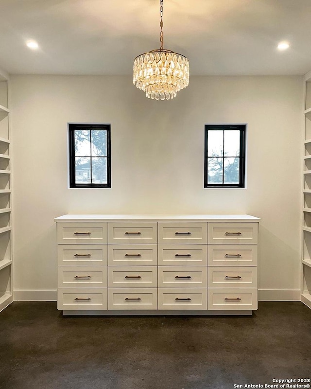 walk in closet featuring a chandelier