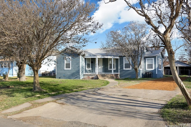 bungalow-style house featuring central AC unit and a front lawn