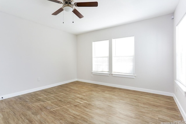 unfurnished room with ceiling fan, light wood-type flooring, and a wealth of natural light