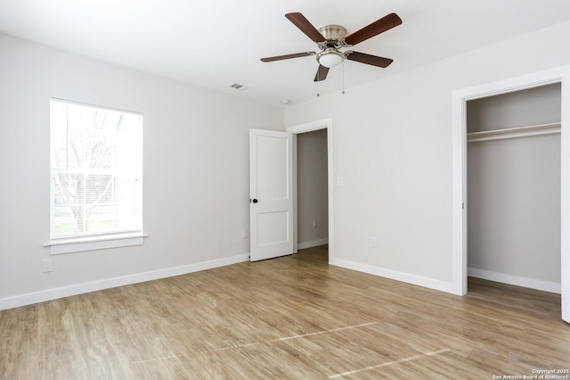 unfurnished bedroom with ceiling fan, light hardwood / wood-style floors, and multiple windows