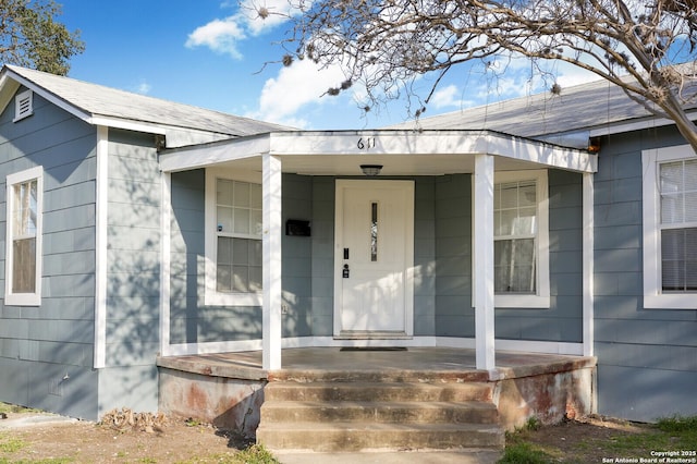 view of exterior entry featuring covered porch