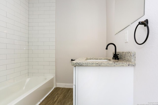 bathroom with vanity, wood-type flooring, and tiled shower / bath