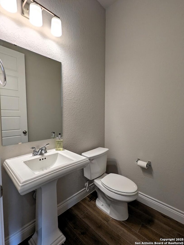 bathroom with hardwood / wood-style floors, sink, and toilet