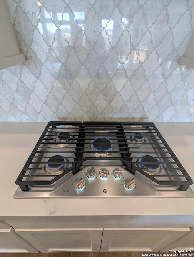 room details with backsplash and stainless steel gas stovetop