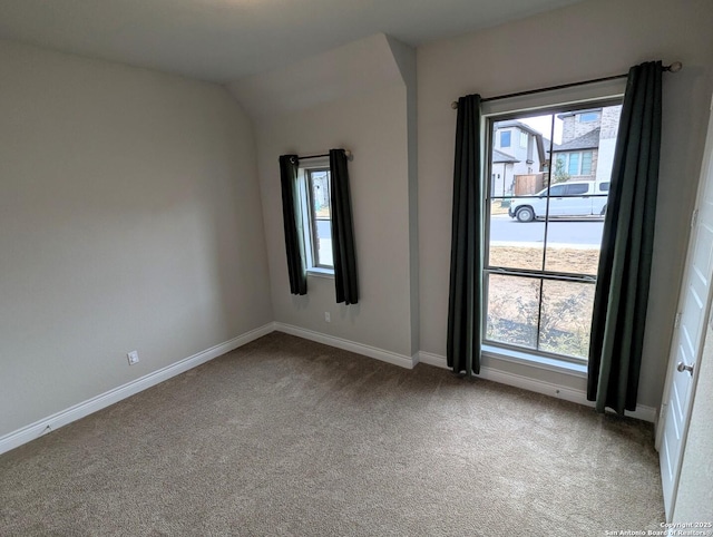 unfurnished room featuring light carpet and vaulted ceiling