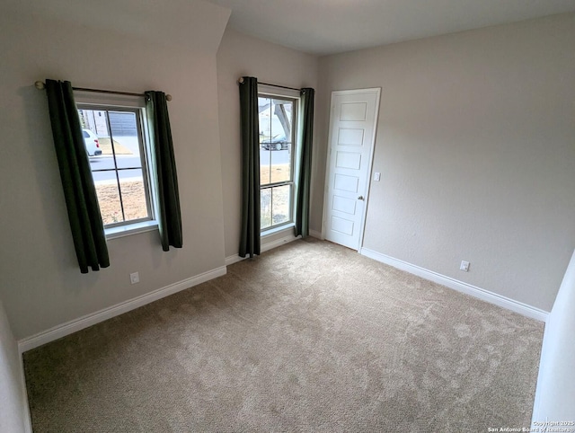 empty room featuring plenty of natural light and light carpet