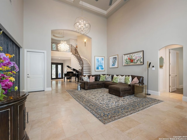 living room featuring coffered ceiling, a notable chandelier, french doors, and a high ceiling