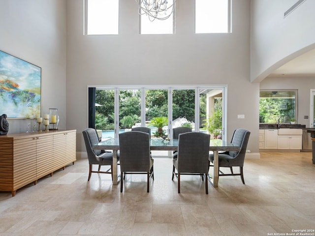 dining area with sink, a healthy amount of sunlight, and a high ceiling