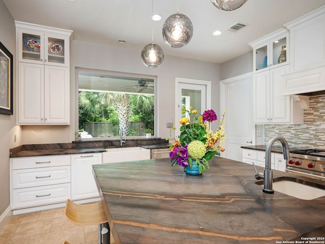 kitchen featuring decorative light fixtures, sink, decorative backsplash, and white cabinets