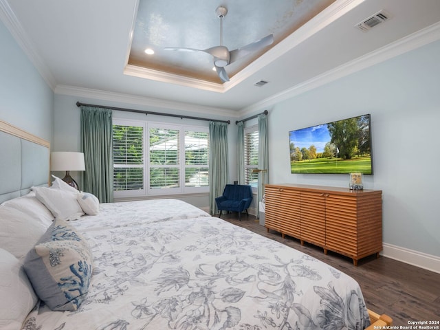 bedroom with dark hardwood / wood-style flooring, ornamental molding, a raised ceiling, and ceiling fan