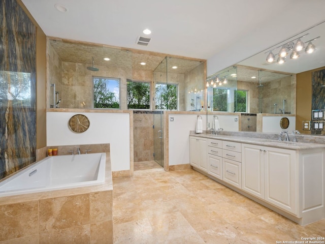 bathroom featuring vanity, independent shower and bath, and tile walls