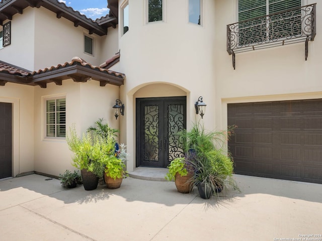 property entrance featuring a garage and french doors