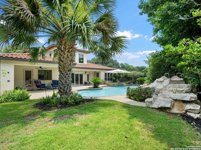 view of swimming pool with ceiling fan, an outdoor hangout area, a patio area, and a lawn