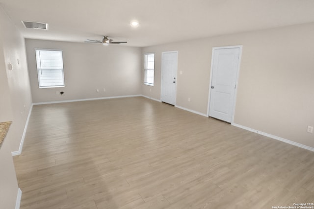 unfurnished room with ceiling fan, plenty of natural light, and light wood-type flooring