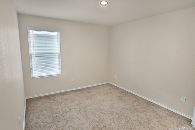 spare room featuring light carpet