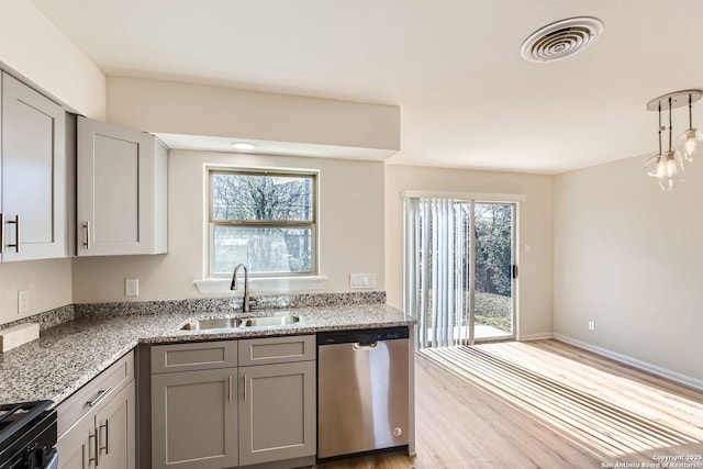 kitchen with stone counters, stainless steel dishwasher, sink, and gray cabinetry