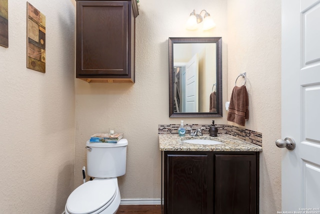 bathroom with vanity, toilet, and backsplash