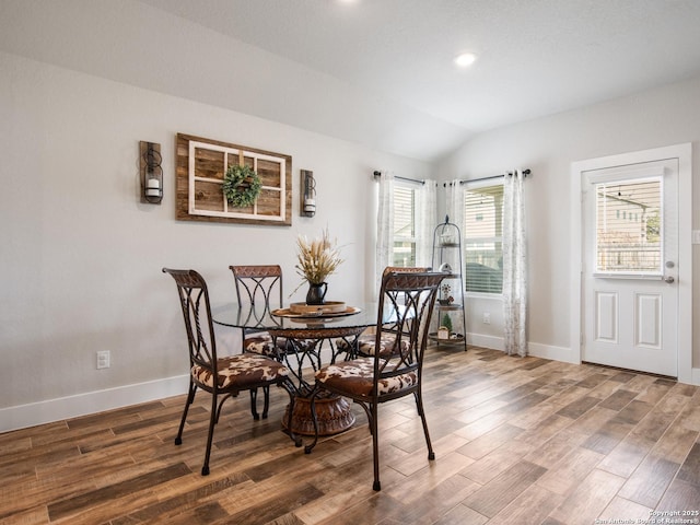 dining space with vaulted ceiling and dark hardwood / wood-style floors