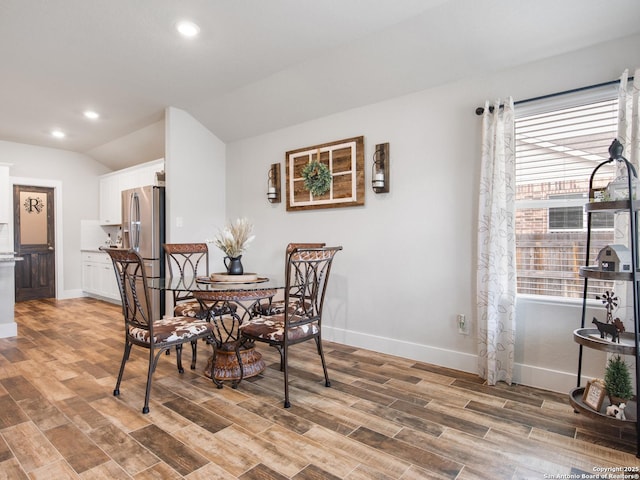 dining area featuring lofted ceiling and light hardwood / wood-style flooring