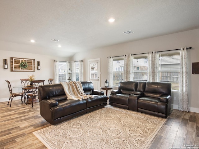 living room featuring light hardwood / wood-style flooring and a textured ceiling