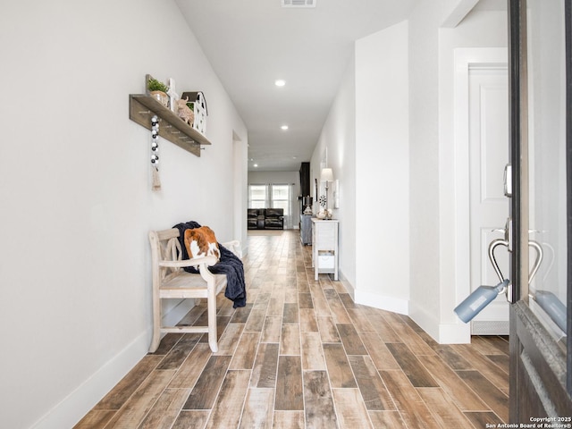 hallway with hardwood / wood-style flooring