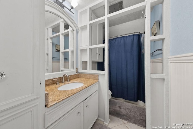 bathroom featuring vanity, curtained shower, tile patterned floors, and toilet