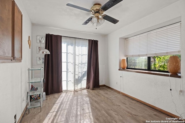 unfurnished room with ceiling fan, light hardwood / wood-style flooring, and a wealth of natural light