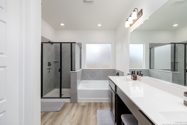 bathroom with independent shower and bath, wood-type flooring, and vanity