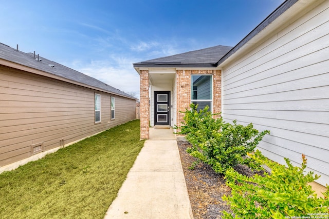 doorway to property with a lawn